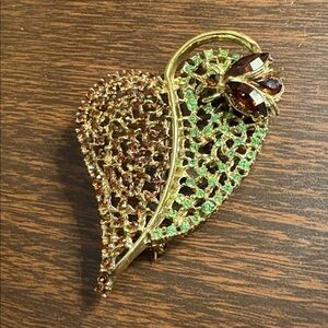 Vintage gold-tone leaf and bee rhinestone brooch.
